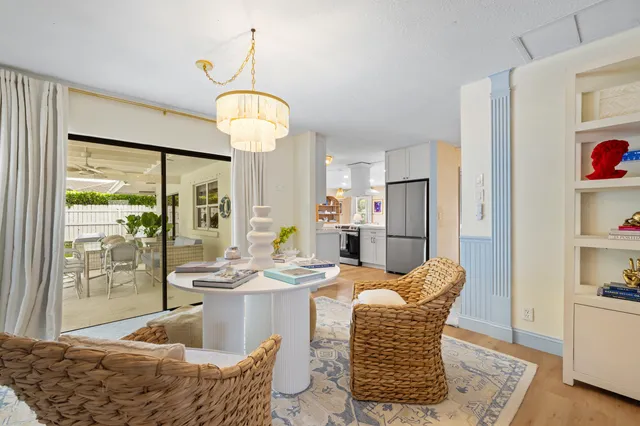 a dining room with furniture a chandelier and wooden floor