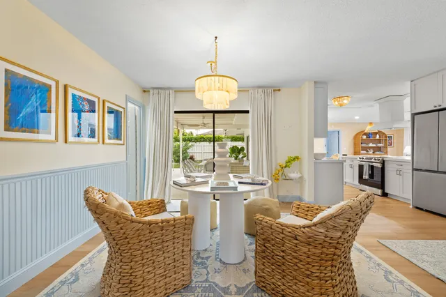 a living room with furniture a chandelier and a dining table