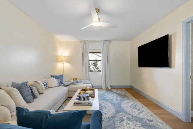 a living room with furniture a flat screen tv and a window