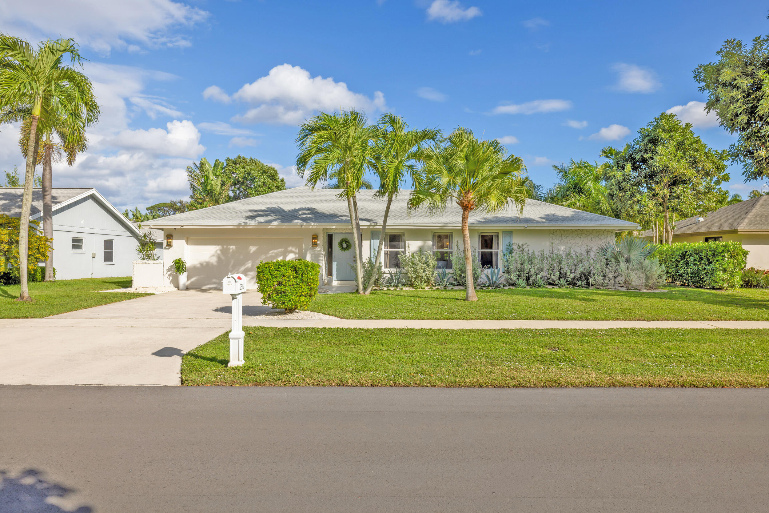 2512 Southwest 5th Street Boynton Beach, FL 33435 - Photo 2 of 37 a front view of a house with a garden and a yard
