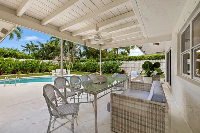 a view of a patio with couches table and chairs with wooden floor and fence
