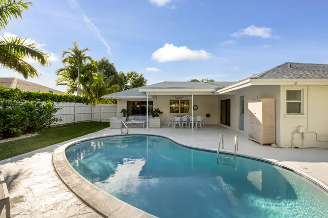 a view of a house with swimming pool and sitting area