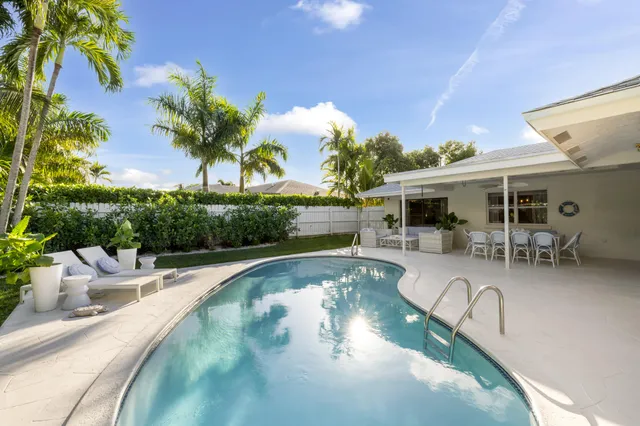 a swimming pool with outdoor seating and yard