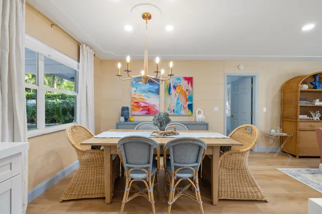 a view of a dining room with furniture a chandelier and wooden floor
