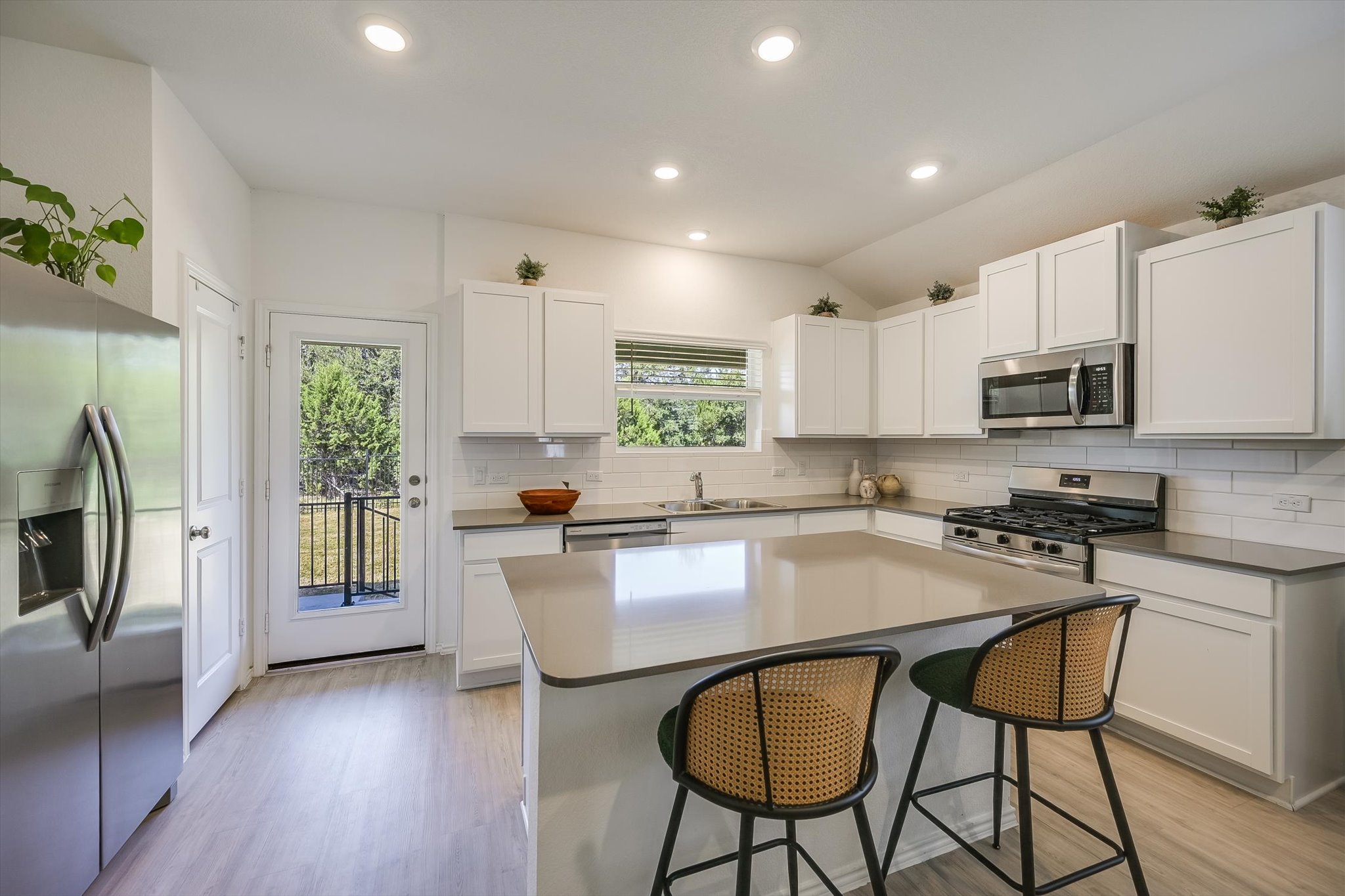 1701 Chapel Ranch Road Georgetown, TX 78628 - Photo 7 of 28 Smooth countertops and crisp shaker cabinets create a modern, light-filled culinary workspace.