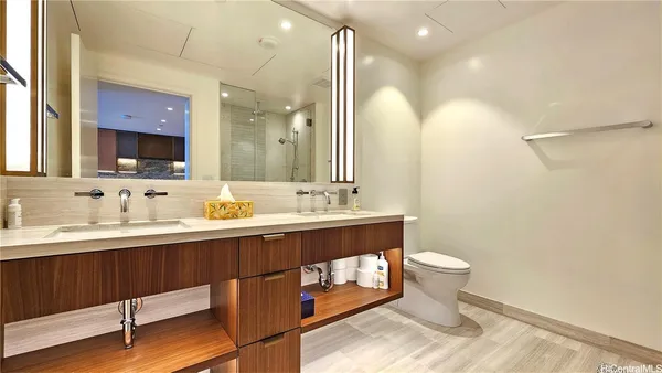 a bathroom with a sink a toilet a mirror and vanity