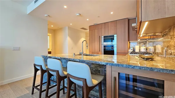 a bathroom with a granite countertop sink and a refrigerator