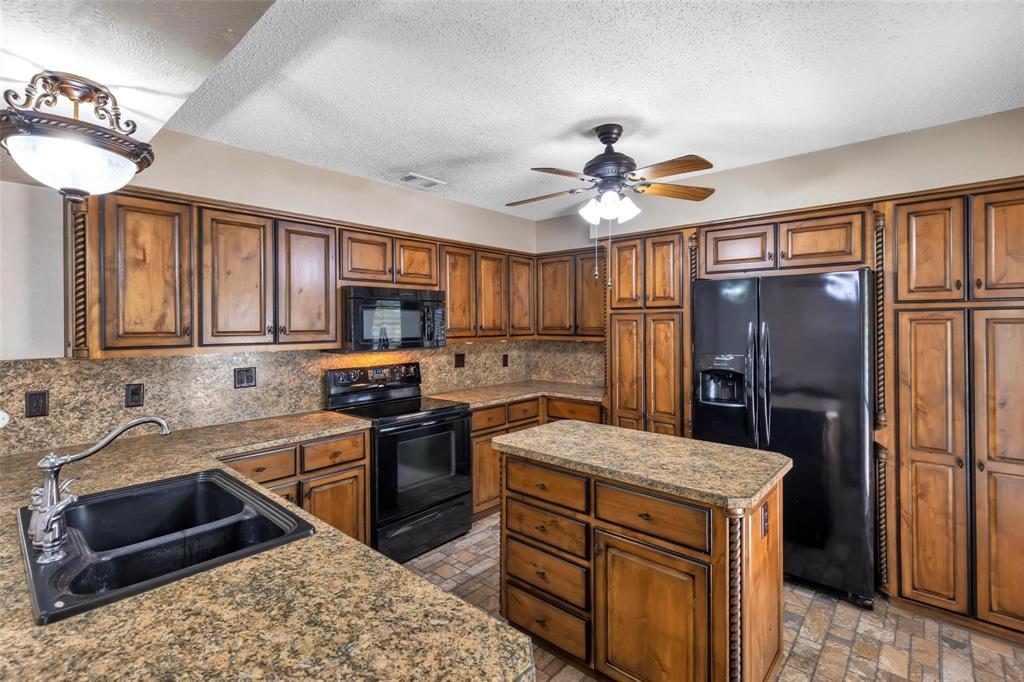 625 Deer Drive Greenville, TX 75402 - Photo 11 of 29 a kitchen with a sink stove and refrigerator