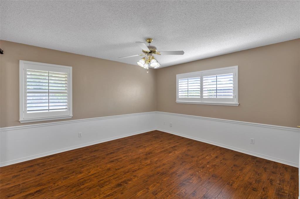 625 Deer Drive Greenville, TX 75402 - Photo 12 of 29 an empty room with wooden floor and windows