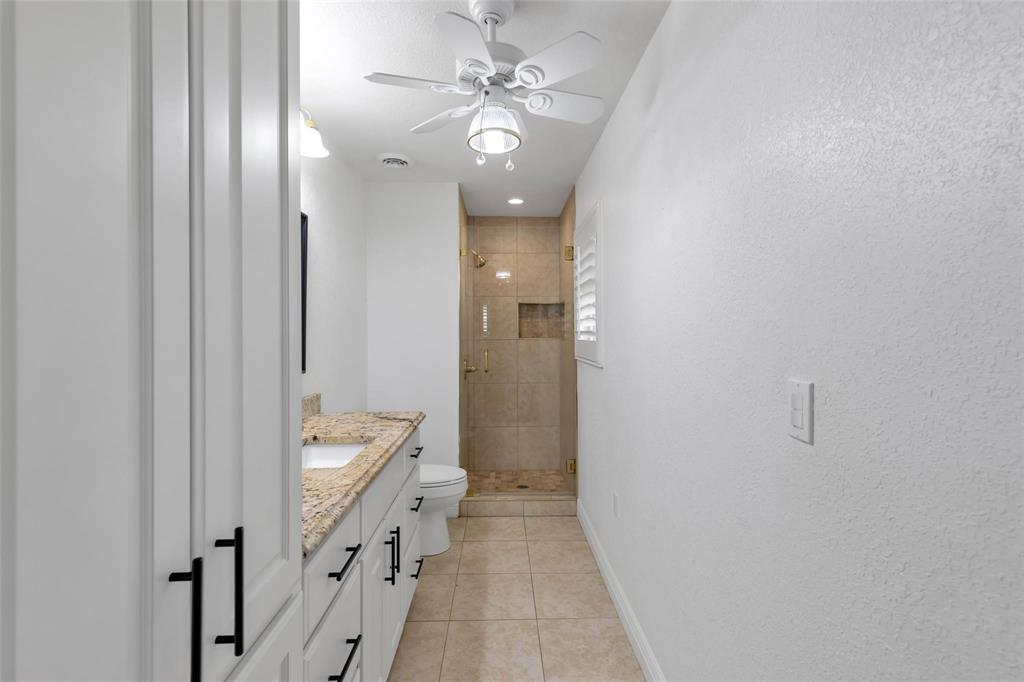 625 Deer Drive Greenville, TX 75402 - Photo 14 of 29 a bathroom with a double vanity sink a toilet a shower and a mirror