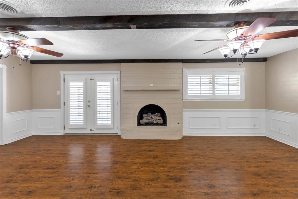 625 Deer Drive Greenville, TX 75402 - Photo 7 of 29 a view of an empty room with a window and wooden floor