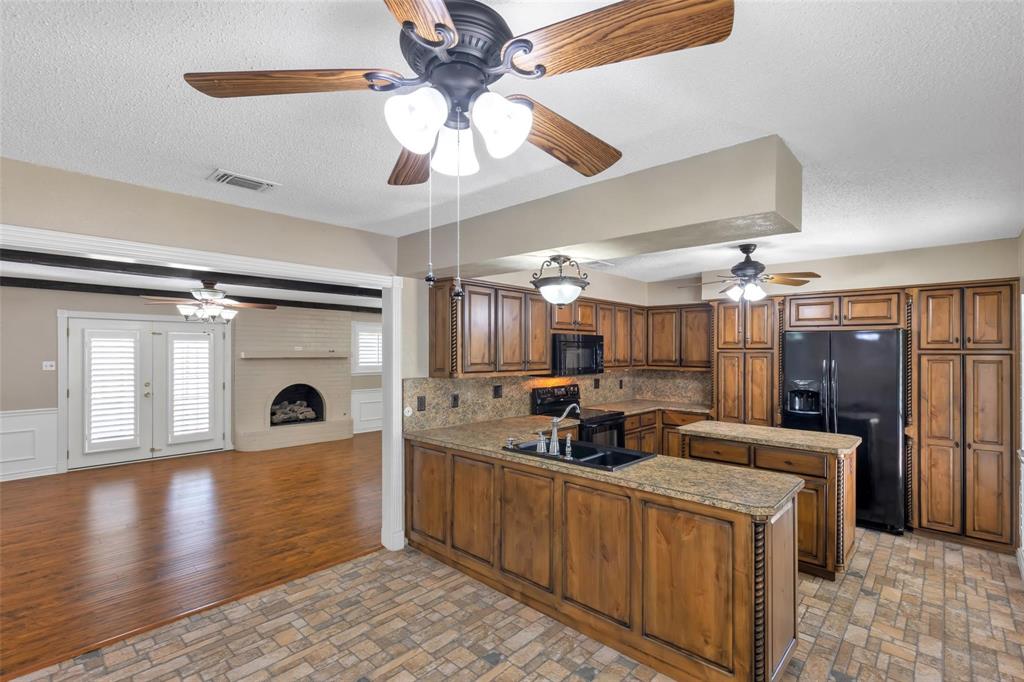 625 Deer Drive Greenville, TX 75402 - Photo 10 of 29 a kitchen with a refrigerator a sink and cabinets