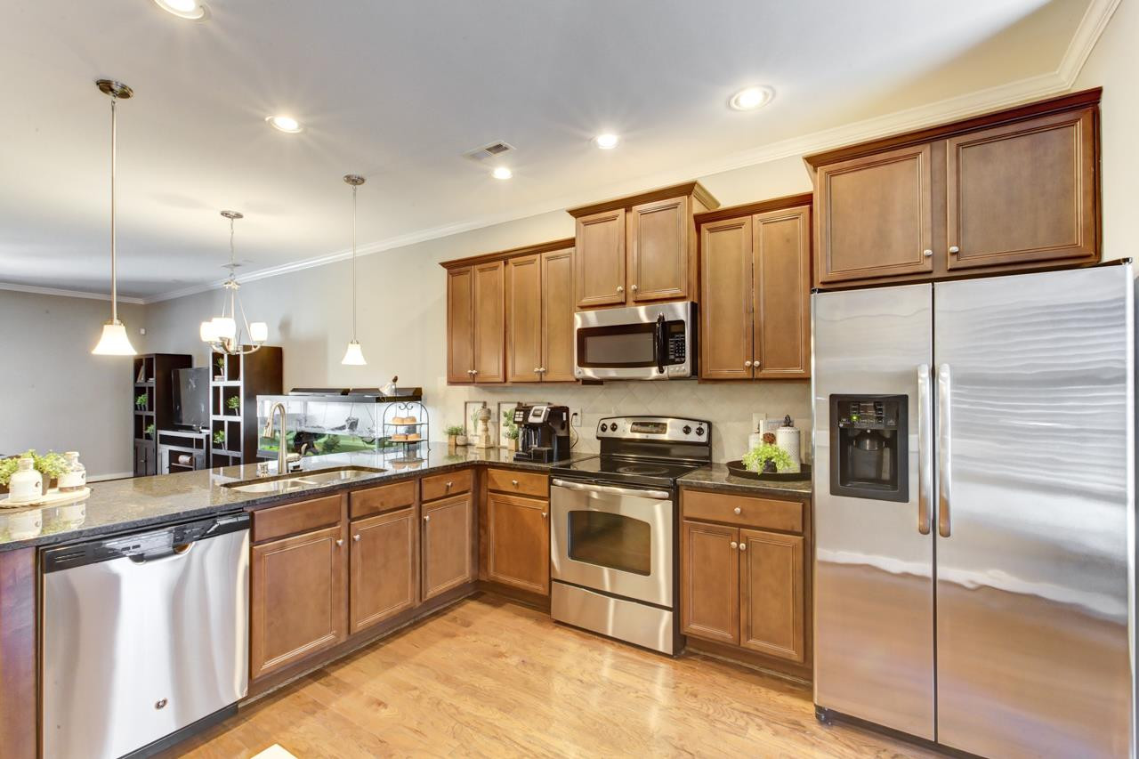 The open kitchen offers GRANITE counters, STAINLESS STEEL appliances, breakfast nook, and a PANTRY. Kitchen