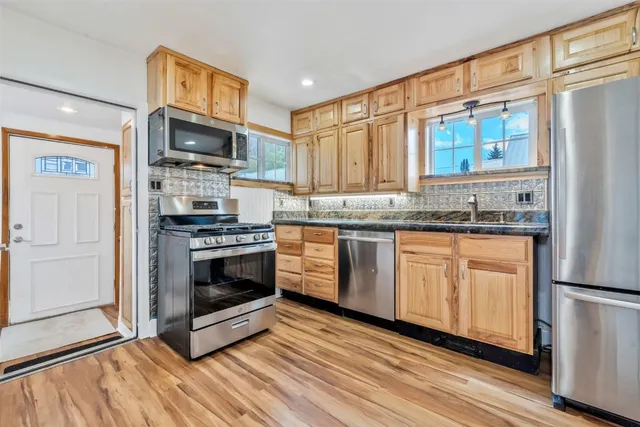 a kitchen with stainless steel appliances a stove a sink and a microwave