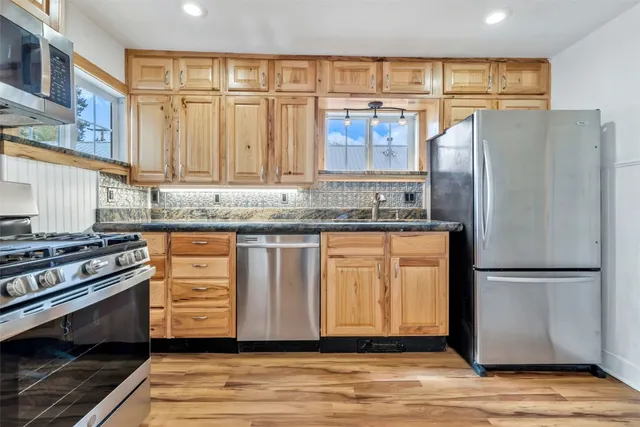 a kitchen with stainless steel appliances granite countertop a refrigerator stove and sink