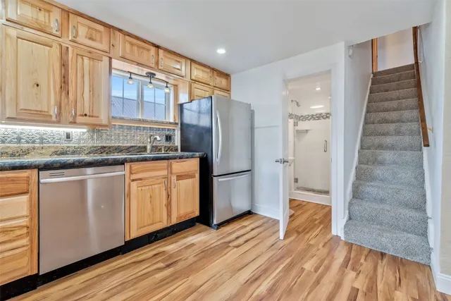 a kitchen with stainless steel appliances granite countertop a refrigerator and a sink