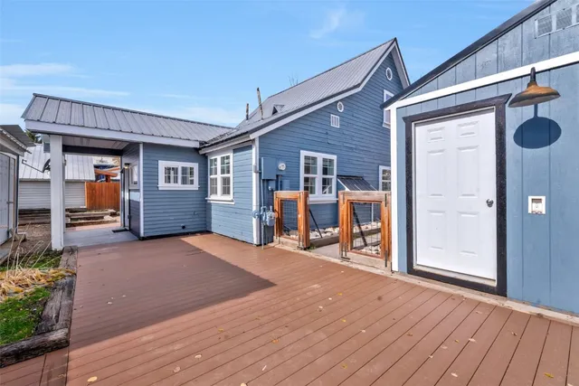 a view of a house with a barbeque and wooden stairs