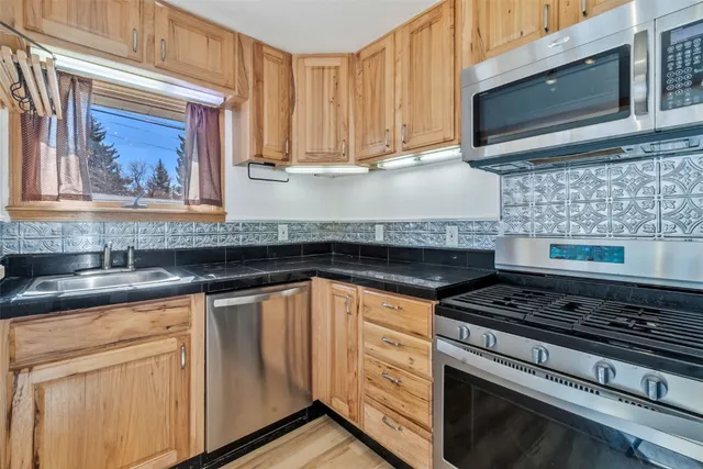a kitchen with stainless steel appliances a stove a microwave and cabinets