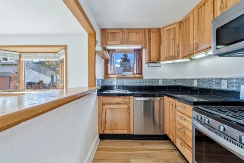 a kitchen with granite countertop a stove sink and cabinets
