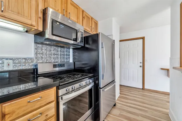 a view of a small space with wooden floor and a window