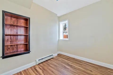 a view of a room with wooden floor and cabinet