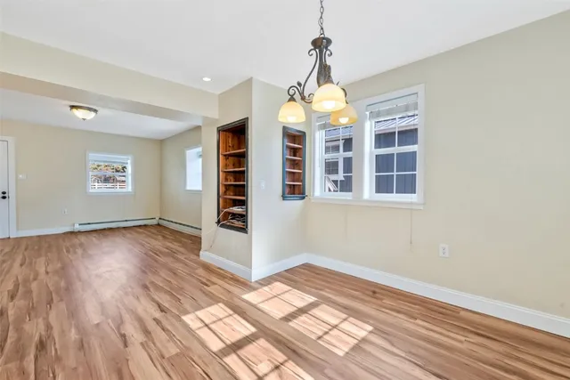 a view of empty room with wooden floor and windows