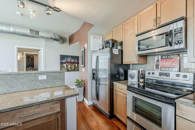 a kitchen with stainless steel appliances granite countertop a stove and a refrigerator