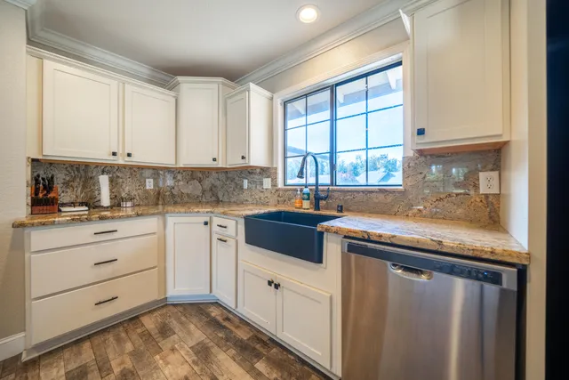 a kitchen with granite countertop white cabinets and white appliances