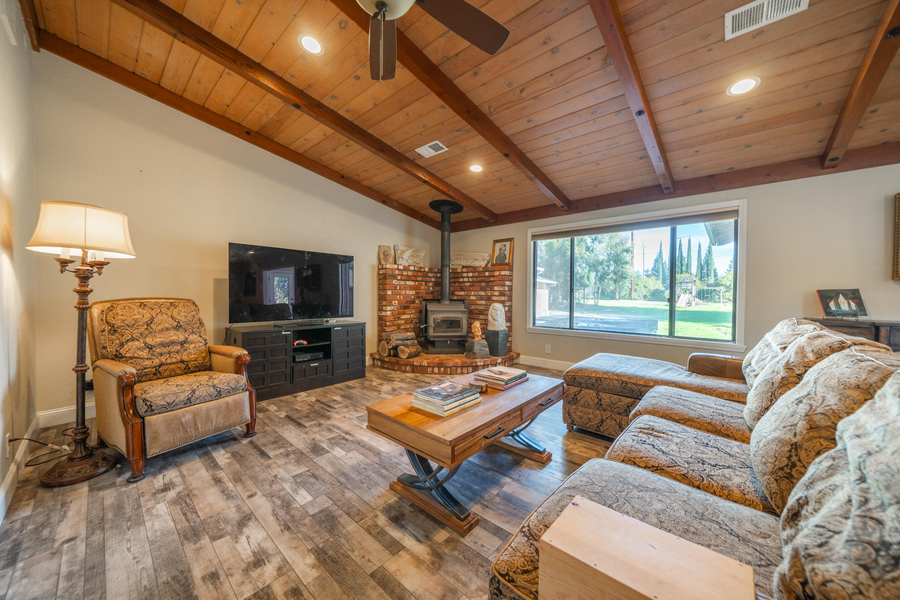 7273 Amigo Way Redding, CA 96002 - Photo 15 of 59 a living room with furniture a flat screen tv and a large window