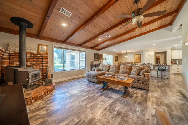 a living room with furniture a fireplace and wooden floor