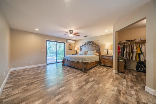 a spacious bedroom with a bed a dresser and a chandelier