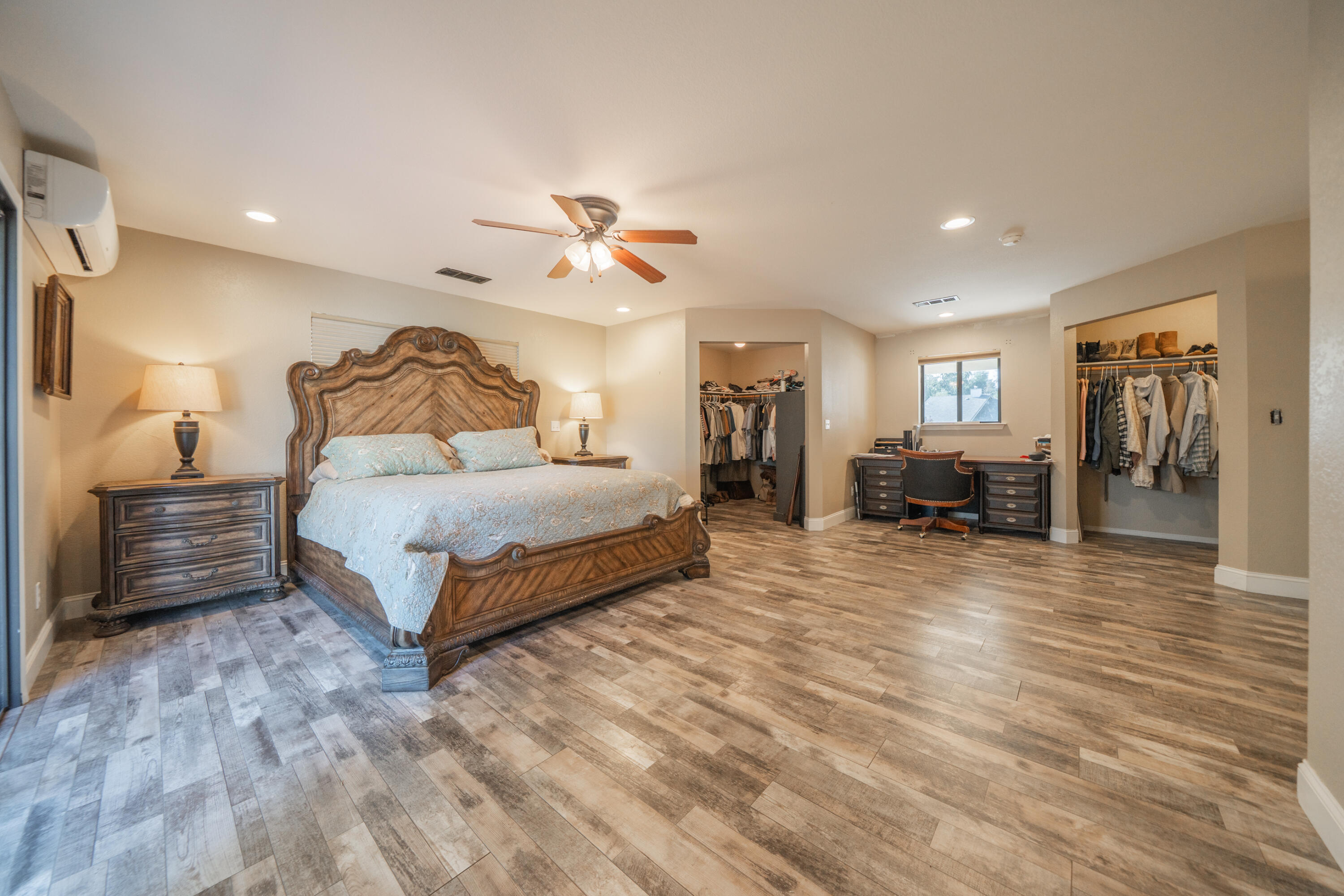7273 Amigo Way Redding, CA 96002 - Photo 30 of 59 a spacious bedroom with a bed a dresser and a chandelier