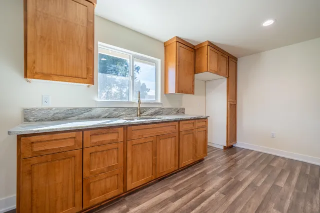 a bathroom with a granite countertop sink and a mirror