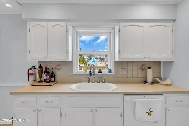 a kitchen with kitchen island granite countertop a sink stainless steel appliances and white cabinets
