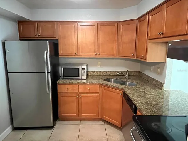 a kitchen with stainless steel appliances granite countertop a refrigerator sink and cabinets