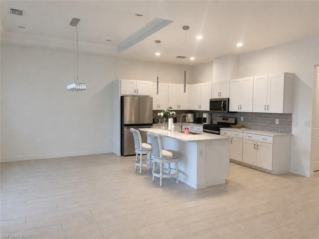 14866 Loggerhead Drive Naples, FL 34120 - Photo 5 of 16 a kitchen with white cabinets and refrigerator