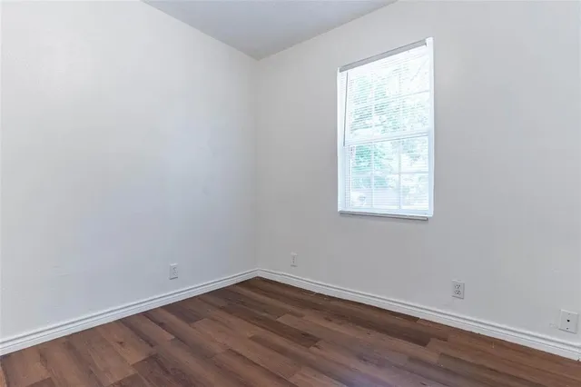 a view of a room with wooden floor and windows in it