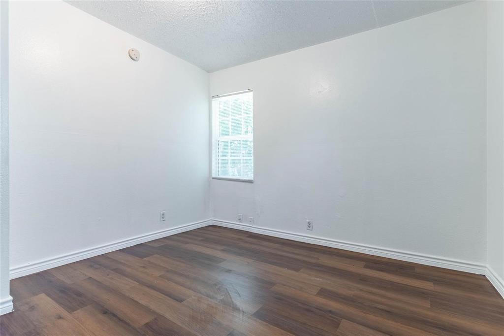 1115 South Frances Street Terrell, TX 75160 - Photo 16 of 20 Unfurnished room with dark wood-type flooring and a textured ceiling