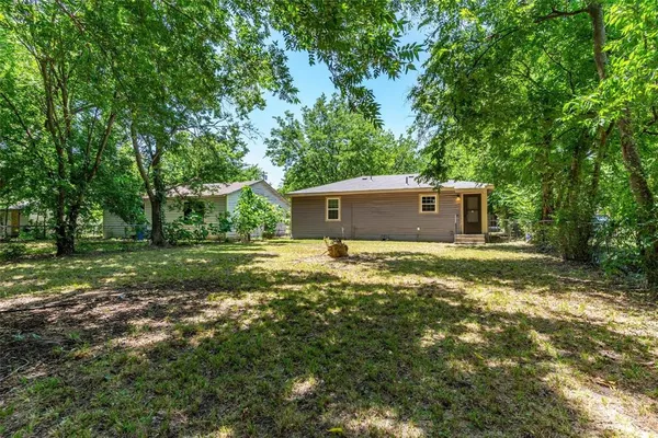 a view of a house with a yard and large trees