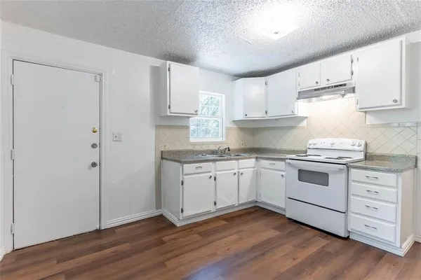 a kitchen with a sink stove and cabinets