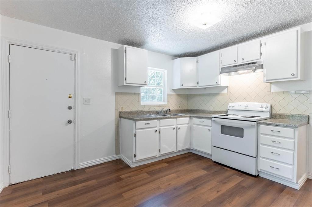 1115 South Frances Street Terrell, TX 75160 - Photo 4 of 20 Kitchen featuring electric range, white cabinetry, dark hardwood / wood-style floors, and sink