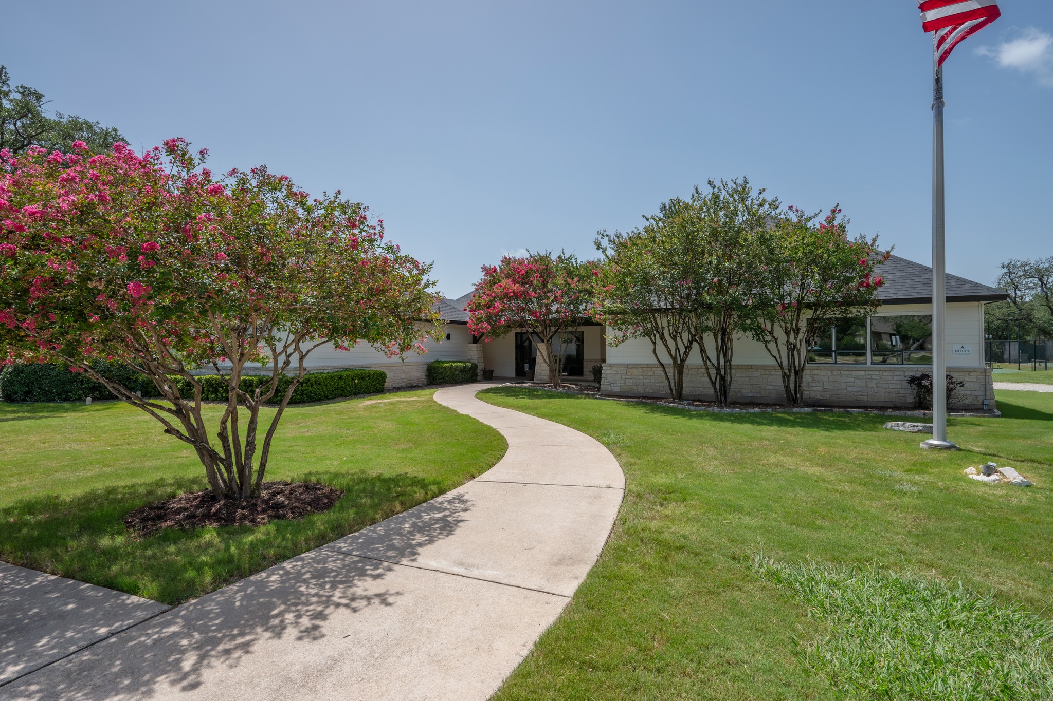 30115 Sawgrass Trail Georgetown, TX 78628 - Photo 34 of 37 A graceful curved walkway guides visitors through manicured lawns to the home's entrance, framed by mature flowering trees.
