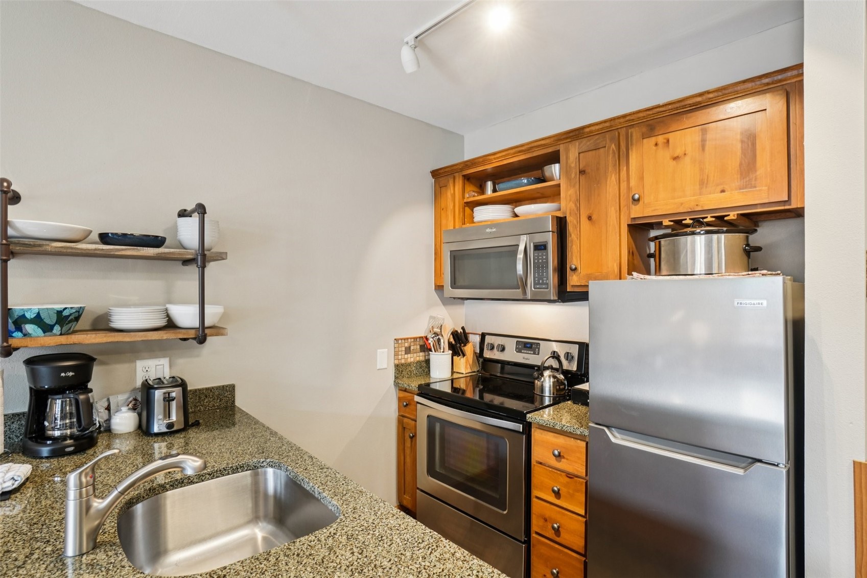 129 River Run Road, Unit 8055 Keystone, CO 80435 - Photo 8 of 50 Kitchen with appliances with stainless steel finishes, open shelves, a sink, brown cabinets, and dark stone countertops