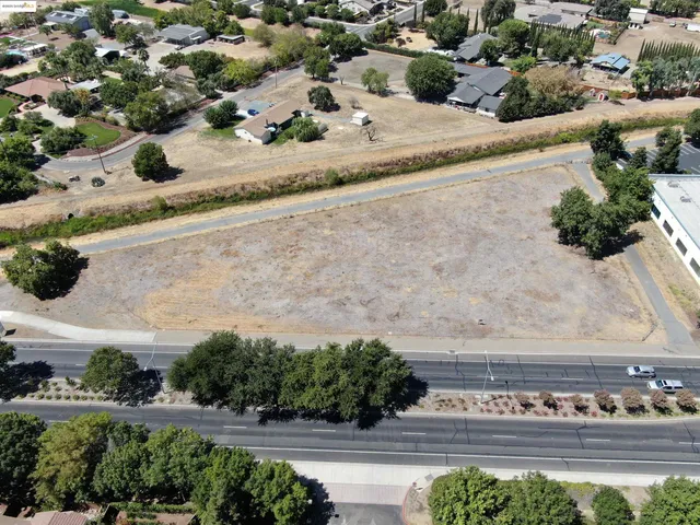an aerial view of a house with a yard and mountain view in back