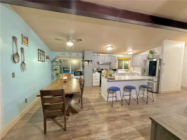 a dining hall with stainless steel appliances kitchen island granite countertop furniture and a kitchen view