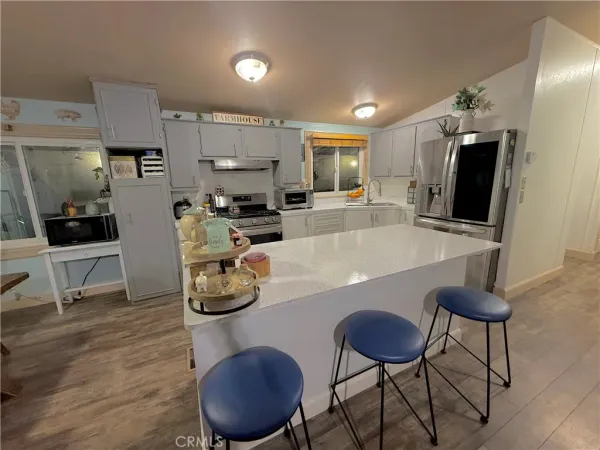 a room with furniture a flat screen tv and kitchen view