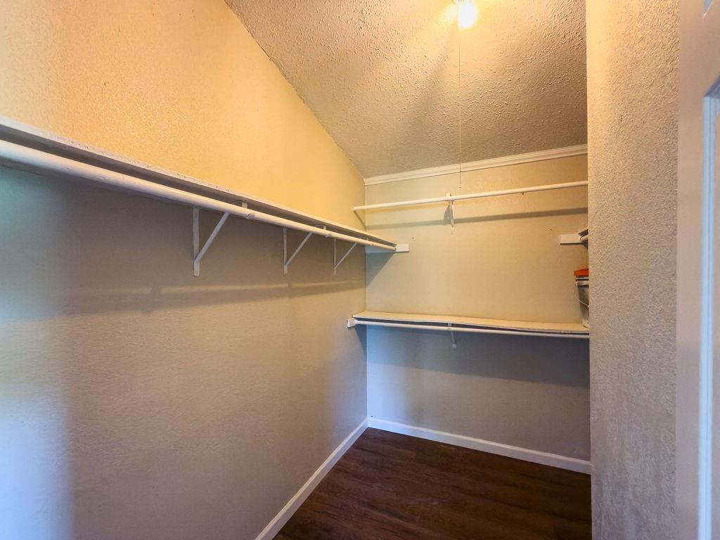 109 Brookshire Street Riesel, TX 76682 - Photo 10 of 18 Walk-in closet with ample storage, featuring wood-finish flooring, multiple shelving units, and clothing rods
