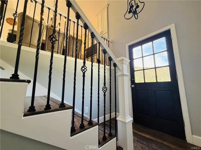 a view of staircase with lots of frames on wall and a window