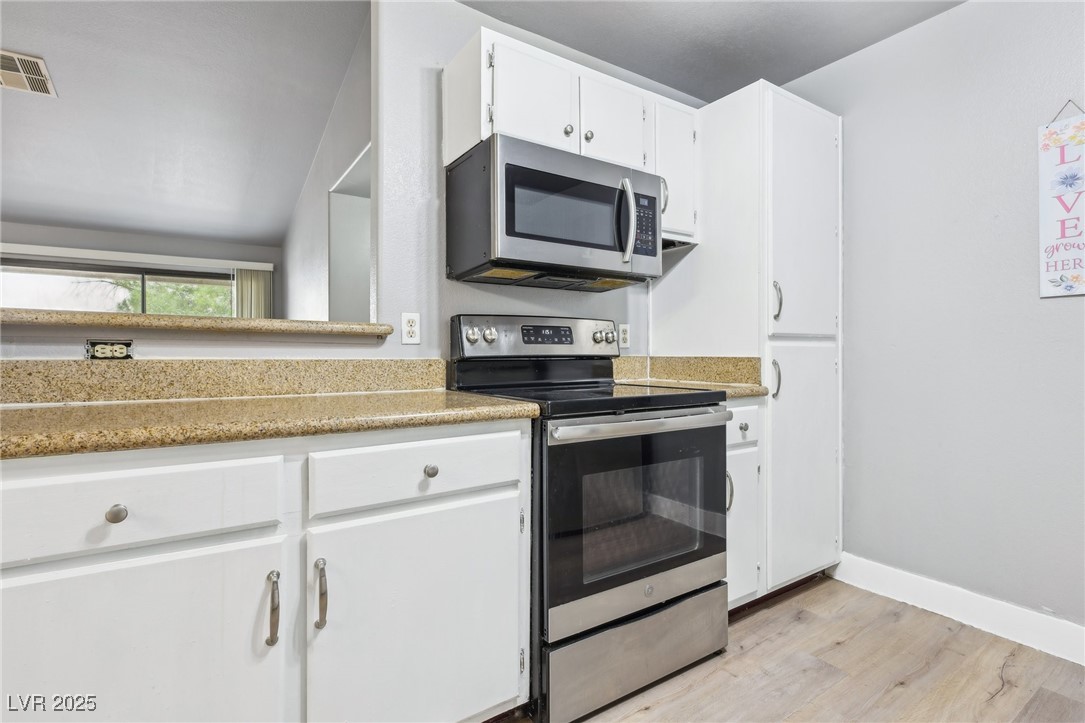 5241 South Lindell Road, Unit 202 Las Vegas, NV 89118 - Photo 15 of 35 Kitchen featuring white cabinetry, baseboards, visible vents, light wood-style floors, and appliances with stainless steel finishes