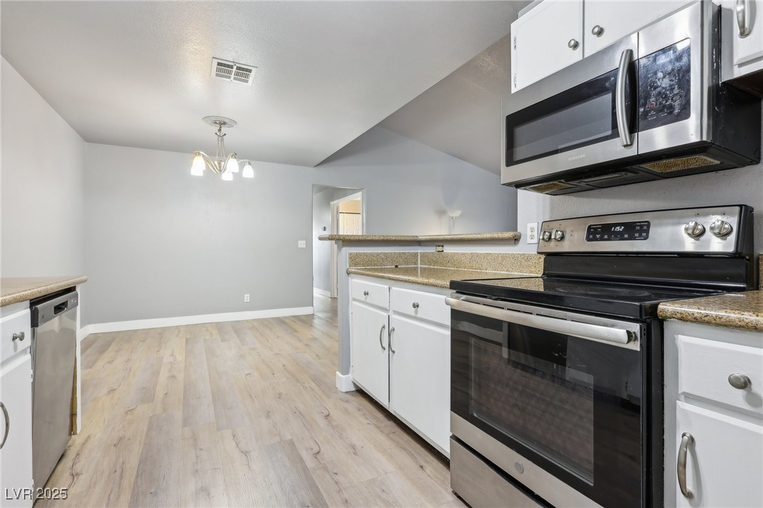 5241 South Lindell Road, Unit 202 Las Vegas, NV 89118 - Photo 18 of 35 Kitchen featuring baseboards, white cabinets, visible vents, stainless steel appliances, and light wood-style floors